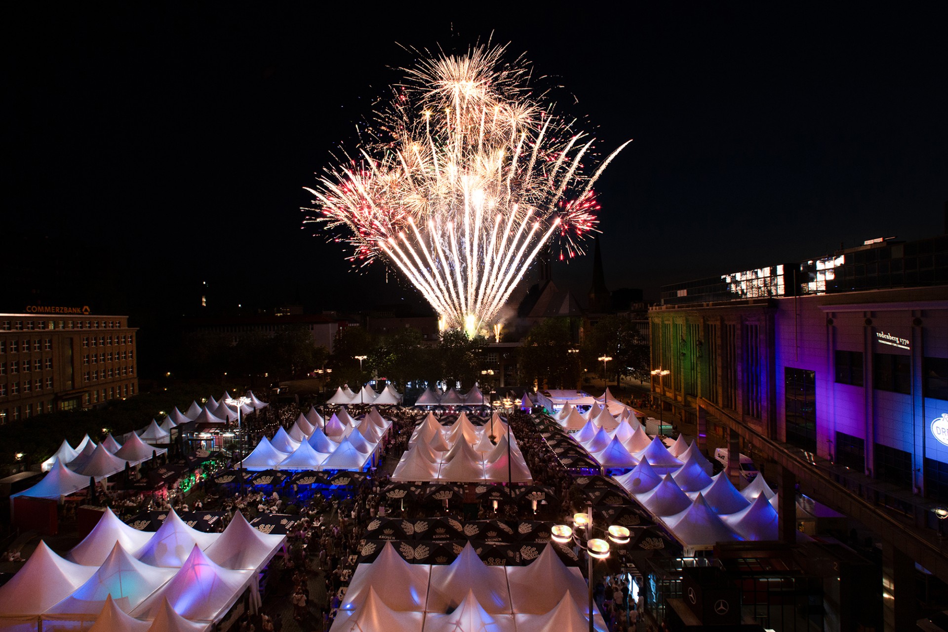 Übersich über den Hansaplatz mit Marktständen im dunkeln, im Hintergrund Feuerwerk.