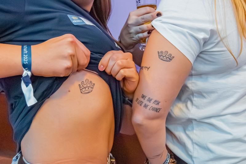 Zwei Personen zeigen ihr Kronentattoo.