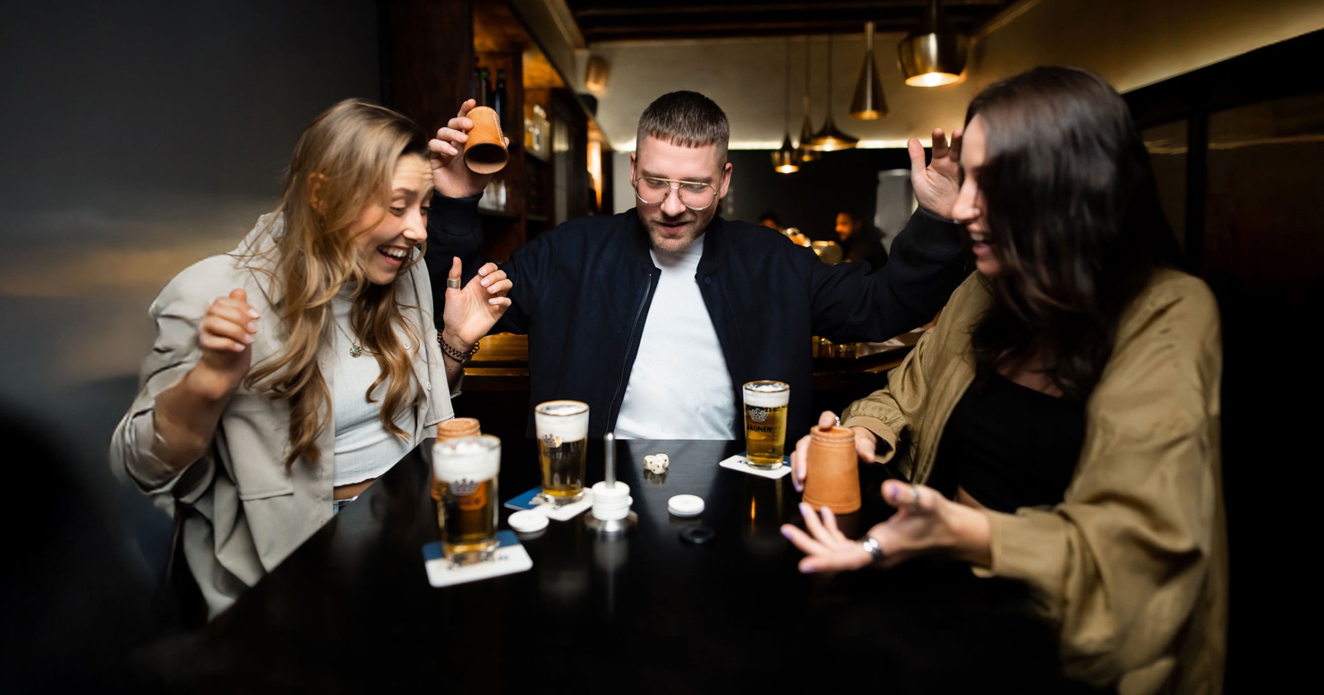 Eine Gruppe von Menschen sitzt an einem Tisch und spielt ein Würfelspiel.