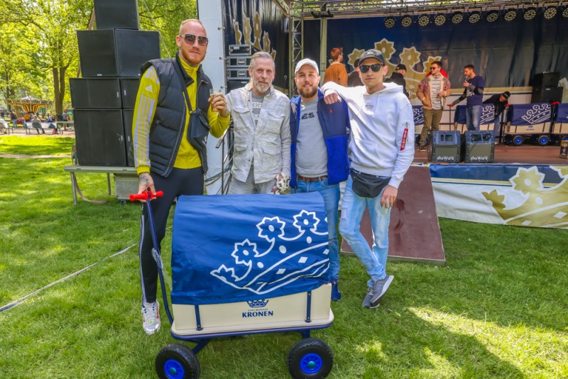 Vier Männer stehen neben einem blauen Wagen auf einer Veranstaltung im Freien.